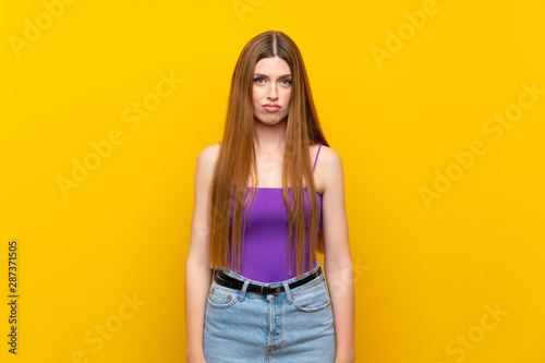 Young woman over isolated yellow background with sad and depressed expression