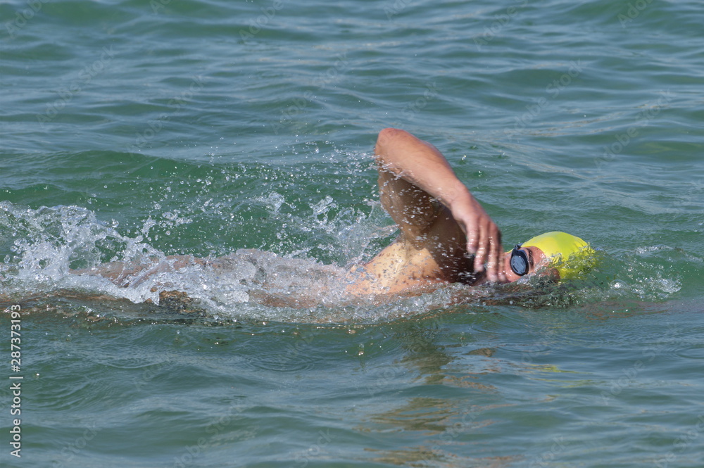 Person swimming freestyle in the see in marathon competition