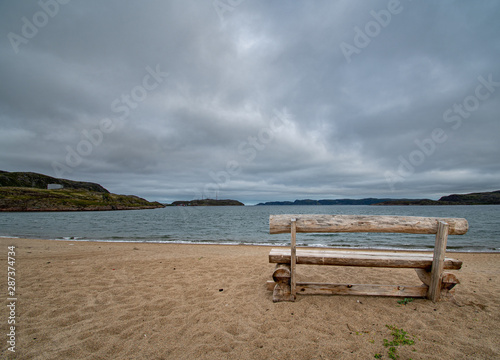 Lonely bench by the sea in autumn