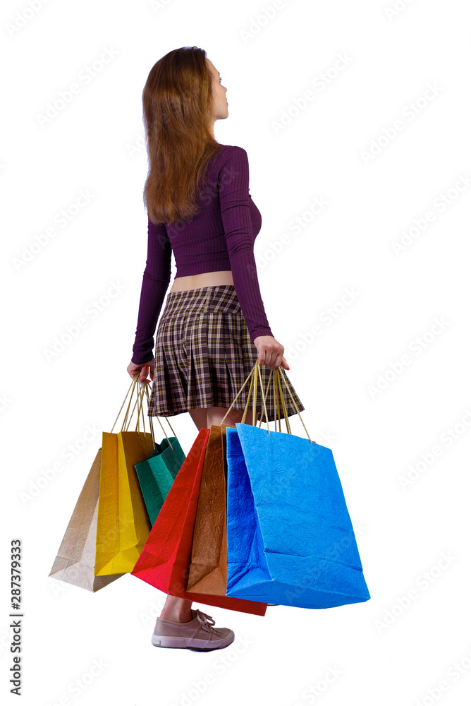 back view of woman in striped T-shirt with shopping bags .
