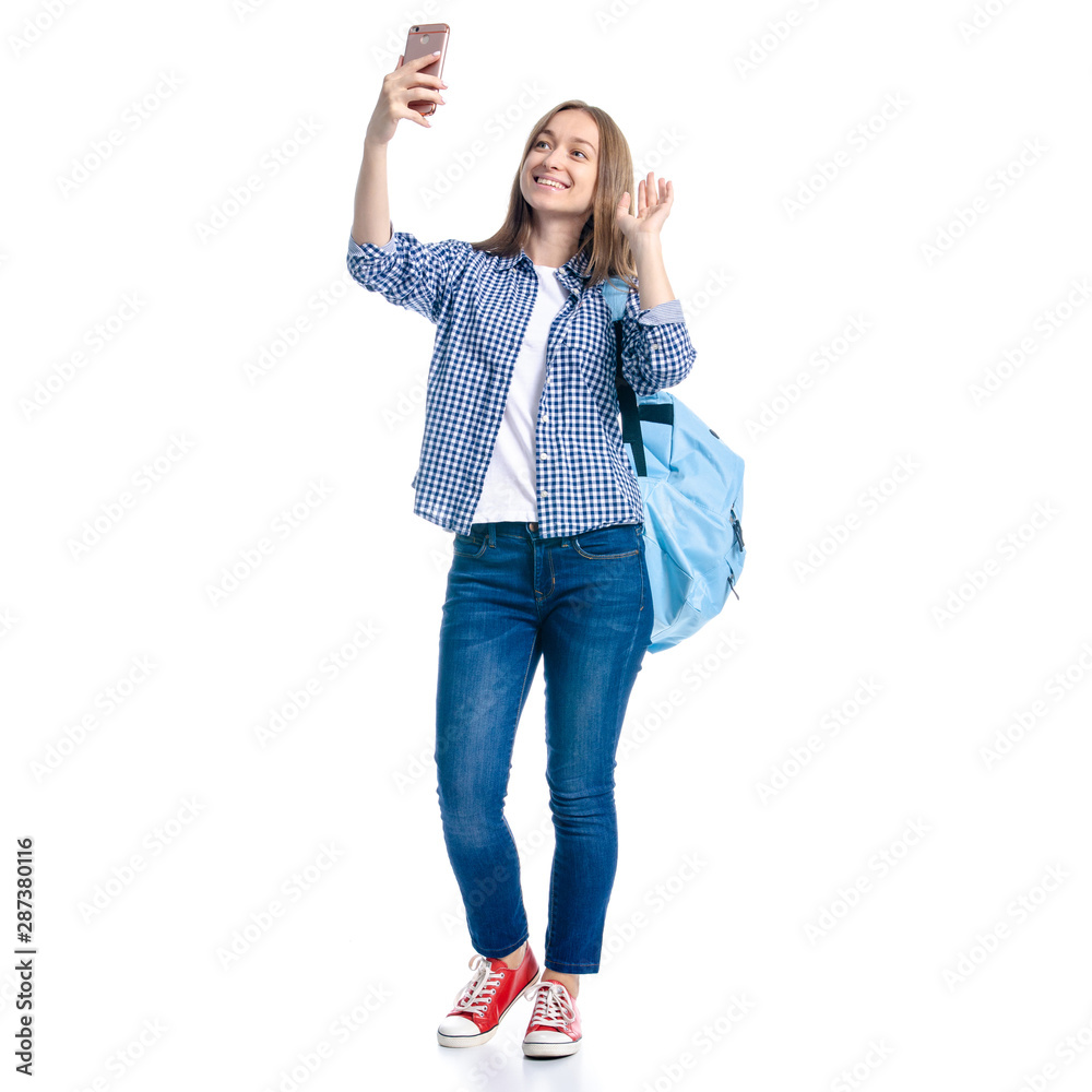 Woman in casual clothing student with backpack standing looking smiling, making selfie smaartphone mobile phone on white background isolation Woman in casual clothing student with backpack standing looking smiling, making selfie smaartphone mobile phone on white background isolation