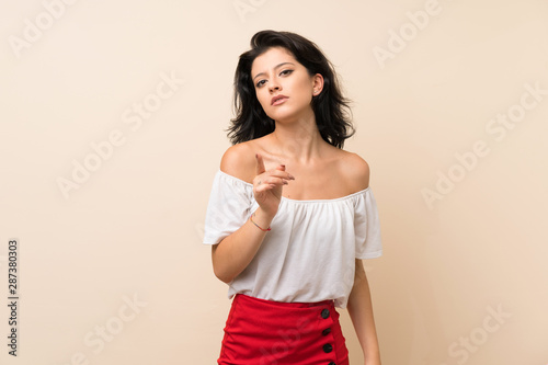 Young woman over isolated background frustrated and pointing to the front
