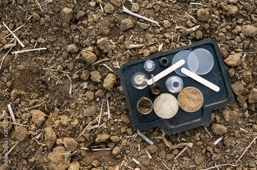 Top view of proessional glassware for testing soil on the ground.Field after harvest photo