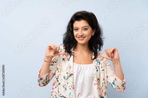 Young woman over isolated blue background proud and self-satisfied