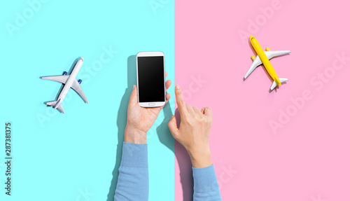 Person holding a smart phone with airplanes from above