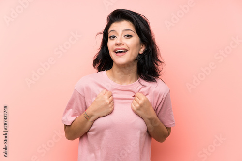 Young woman over isolated pink background celebrating a victory