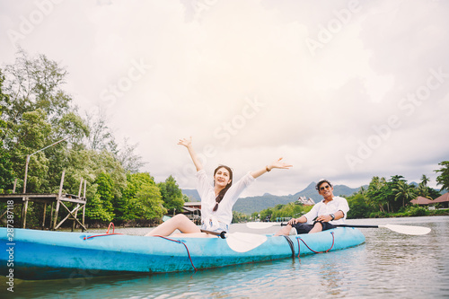 Young happy tourists sightseeing and kayaking on the river