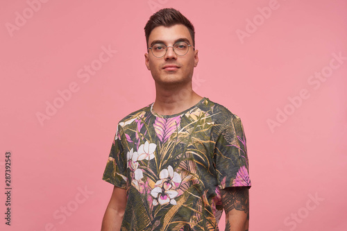 Wallpaper Mural Indoor portrait of attractive young short haired man in casual t-shirt posing over pink background, looking calmly to camera with confident appearance Torontodigital.ca
