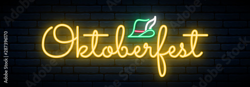 Oktoberfest neon signboard. Light bright lettering on brick wall background.