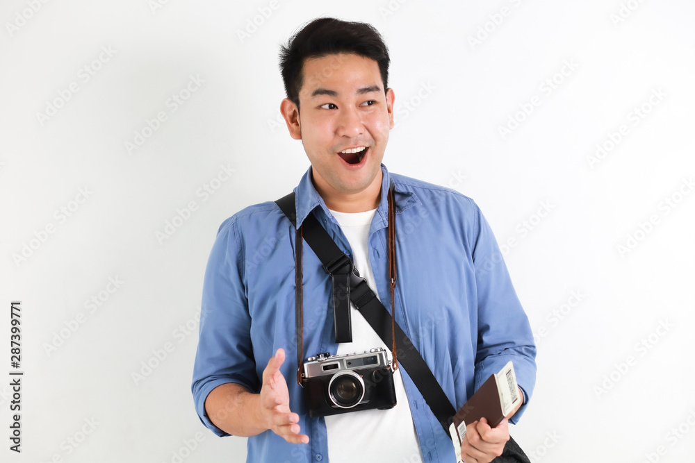Young Asian handsome man in blue shirt and retro film camera with bag on white background travel concept Young Asian handsome man in blue shirt and retro film camera with bag on white background travel concept