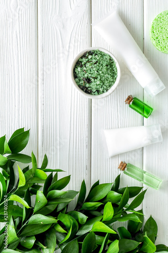 organic cosmetic with herbs on white wooden background top view photo