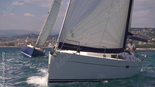 Two sailing boats cut through the water on the sea in super slow motion. Off the coast of Cannes.