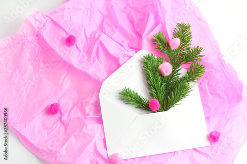 Fototapeta Naklejka Na Ścianę i Meble -  Christmas concept. composition on a pink background. white open envelope, spruce branches and multi-colored pompons shot from the top. flat lay, copy space