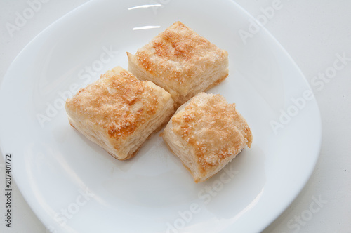 puffs of dough sprinkled with sugar on a white plate