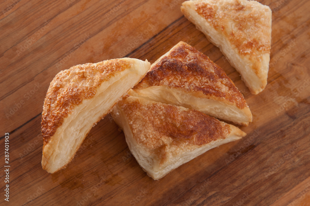 puffs of dough sprinkled with sugar on a wooden tray