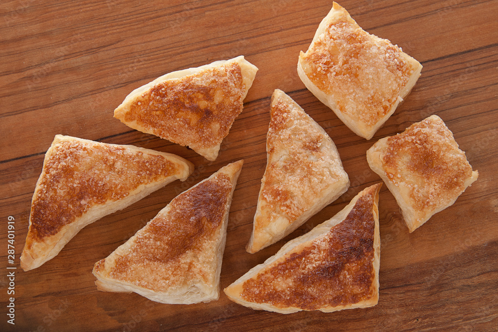 puffs of dough sprinkled with sugar on a wooden tray puffs of dough sprinkled with sugar on a wooden tray