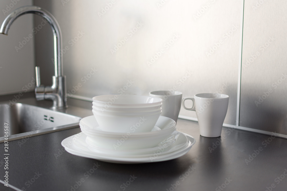 Set of fresh washed plates and cutlery on the kitchen table. Set of fresh washed plates and cutlery on the kitchen table.