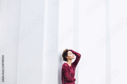 Free Download Young beautiful adult girl with natural makeup fashionable and happy on white building wall background - GFXLoad