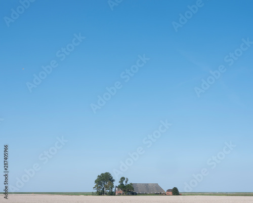 deserted farm in the north of dutch province groningen on sunny summer day.