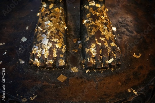 Foots of Buddha statue with gold leaf in temple 