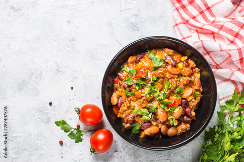 Chili con carne from meat and vegetables on stone table top view.