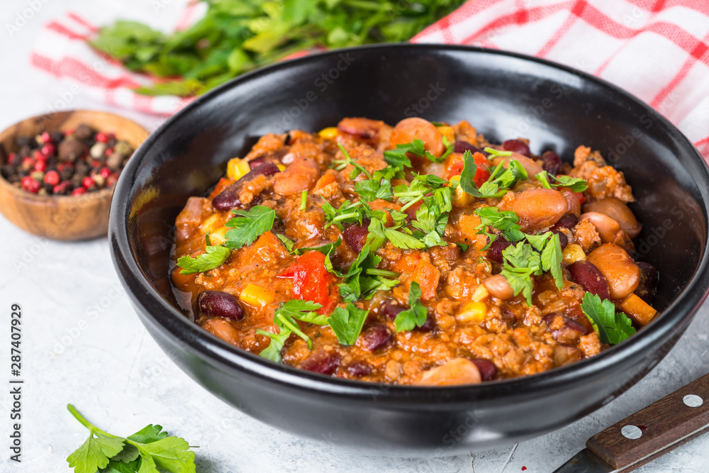 Chili con carne from meat and vegetables on stone table close up. Chili con carne from meat and vegetables on stone table close up.