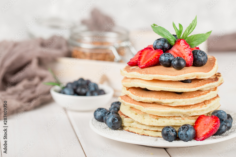 Classic american pancakes with fresh berry on white wood background. Summer homemade breakfast. Classic american pancakes with fresh berry on white wood background. Summer homemade breakfast.