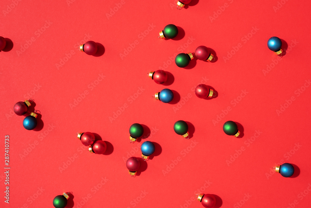 Christmas pattern made of colorful christmas baubles on red background. Flat lay, top view. New year concept Christmas pattern made of colorful christmas baubles on red background. Flat lay, top view. New year concept