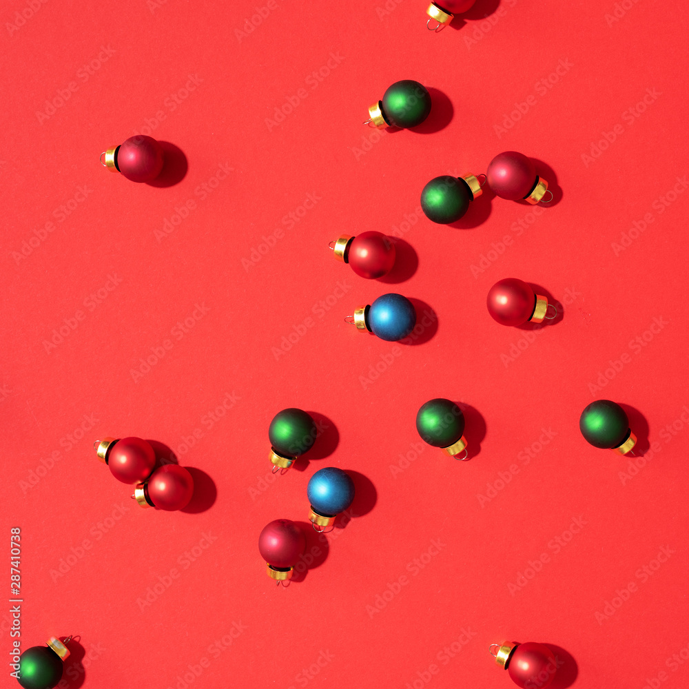 Christmas colored baubles. Festive pattern made of new year baubles on red background. Flat lay, top view. Minimal design greeting card Christmas colored baubles. Festive pattern made of new year baubles on red background. Flat lay, top view. Minimal design greeting card