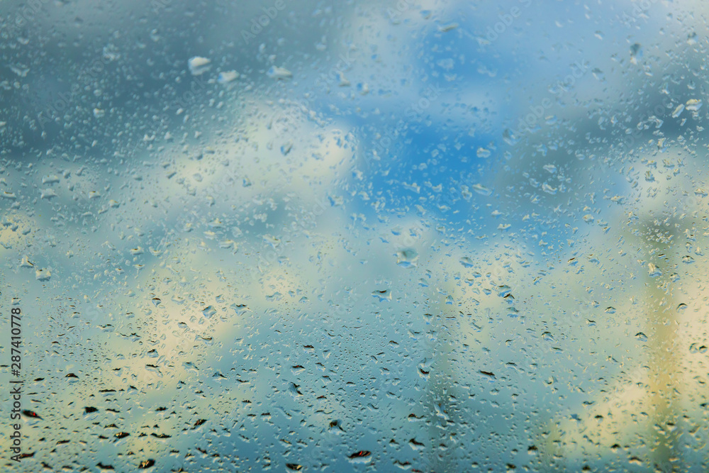 Rain during driving on the window glass. Drops of rain
