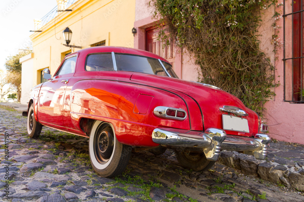 Red automobile on one of the cobblestone streets, in the city of Colonia del Sacramento, Uruguay. It is one of the oldest cities in Uruguay.