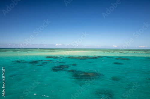 The Beautiful Great Barrier Reef from Above Aerial of Coral and Australia Mountains in Background with Blue Sky in Summer Weather