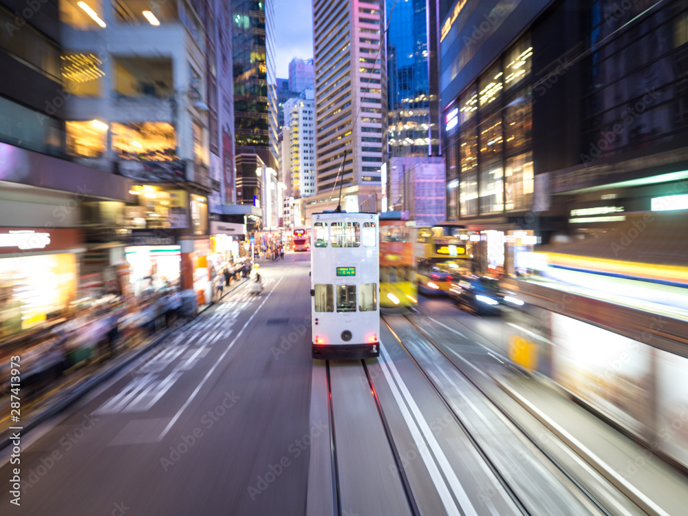 Double Decker Hong Kong Tram also known as Ding Ding at night through city streets. Motion blur.