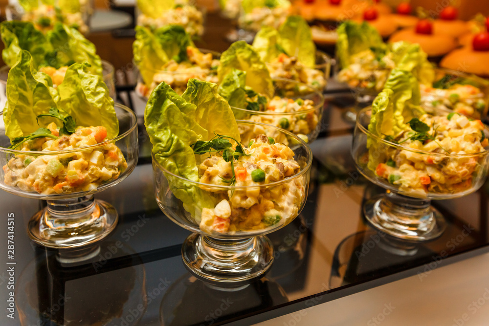 Catering banquet table with vegan vegetarian snacks. Vegetable salad in glass salad bowls. Corporate christmas birthday party event wedding celebration