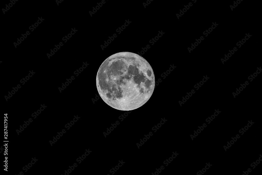 A portrait of a full moon shining bright at night in the darkness of endless space. A portrait of a full moon shining bright at night in the darkness of endless space.