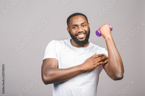 Fitness concept. Portrait of a happy african american black man with dumbbells isolated over grey background.