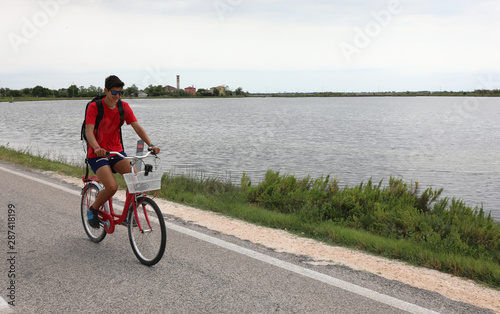 young boy rides bike on the road photo