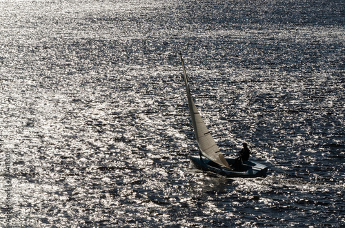 REGATTA IN SUNNY RAYS - Sailboat on the waves of the lake photo