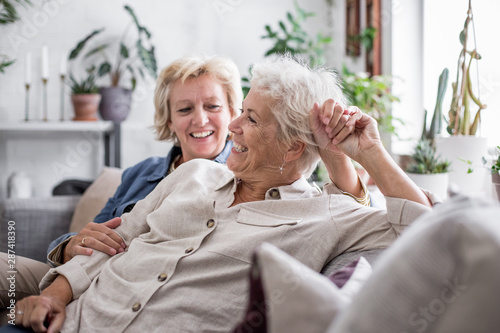 Mature lesbian couple at home on sofa photo