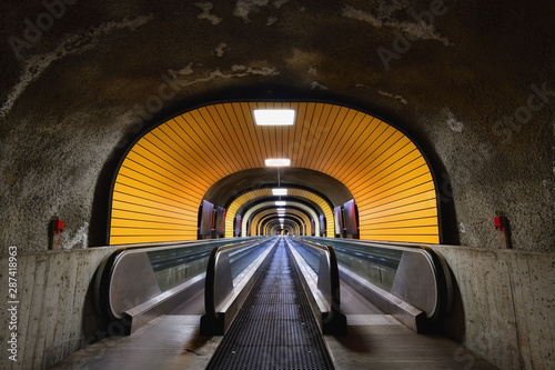 Pedestrian subway, illuminated tunnel, with two moving walkways. photo