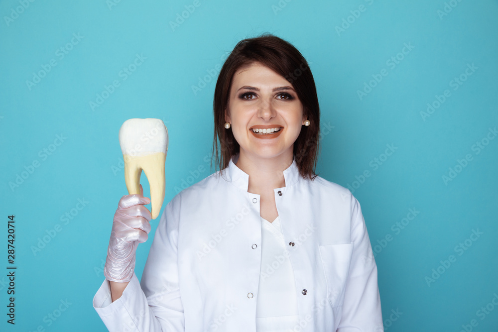 Dentist in gloves holding medical stuff isolated in the blue studio