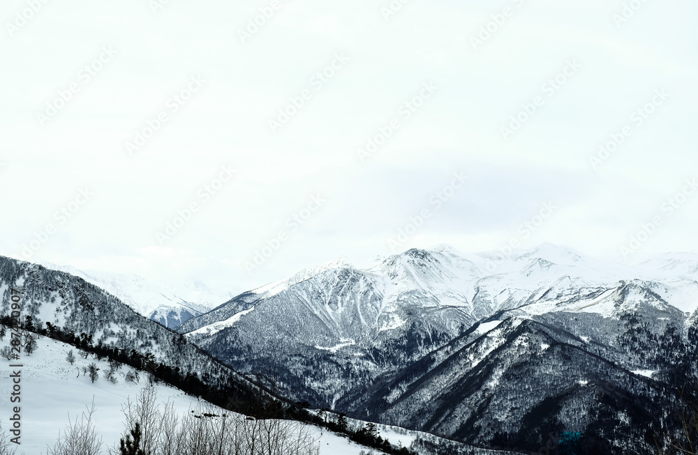 Obraz premium Snow-capped mountain peaks of the Caucasus mountain range near the resort of Arkhyz. Mountain peaks covered with snow in winter. Winter landscape.