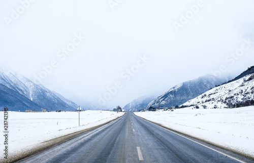 The road in the snow-capped mountains . Winter landscape.