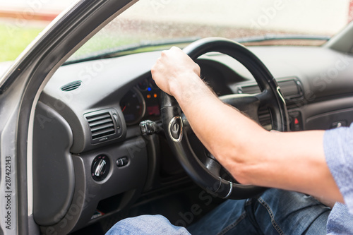 .men's hands on the wheel of a car © kott73