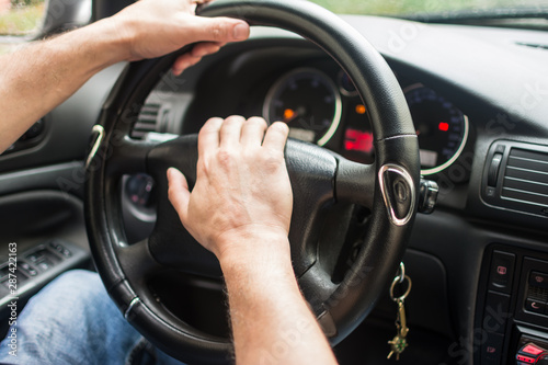 .men's hands on the wheel of a car © kott73