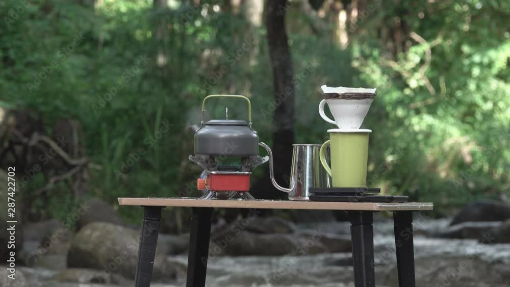 drip coffee , Barista pouring water on coffee ground with filter in morning  view, Coffee Drip on a wooden table