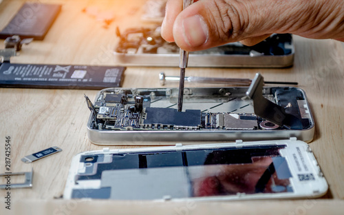 Iphone motherboard repairs into the motherboard for smartphone By professional technician on desk