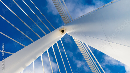 Northern Spire Cable Stayed Bridge in Sunderland spanning the River Wear. Photo taken of the top spire of the bridge showing cables and the white metal structure against the blue sky.