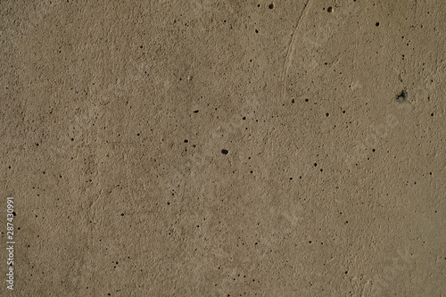 Dark and subdued texture of a cement plaster wall.