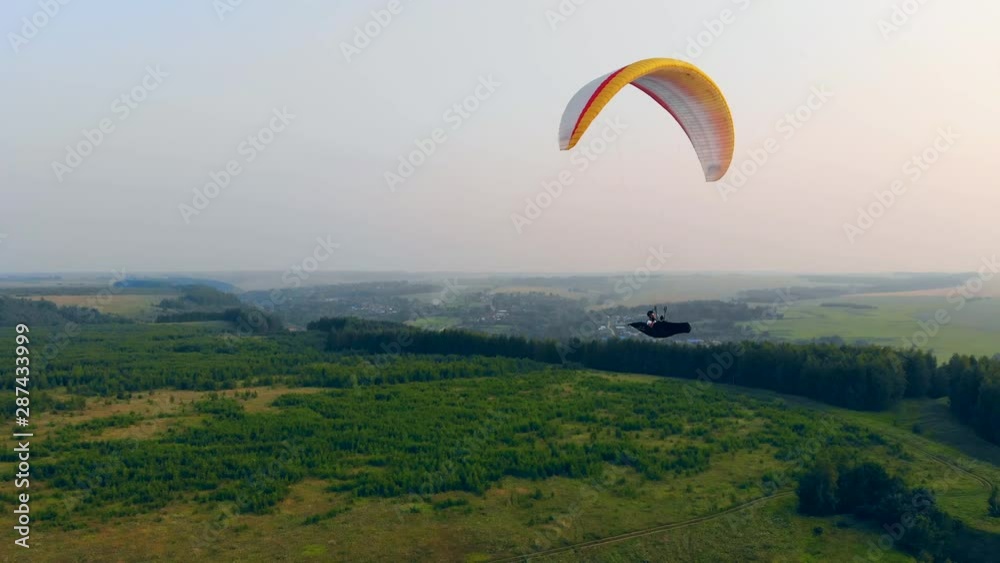 Athlete flies a glider in sky. Adventure, active extreme lifestyle concept.